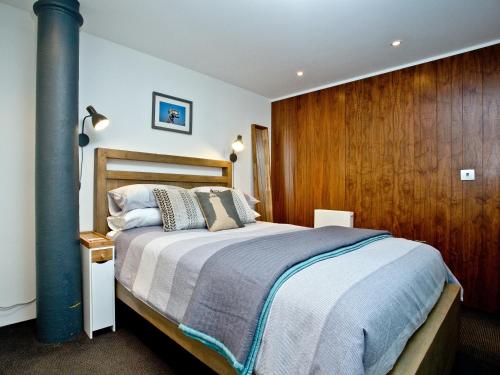 una camera con un grande letto e una parete in legno di The Sail Loft - Royal William Yard a Millbrook