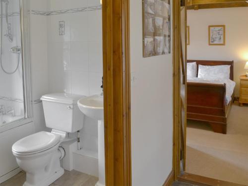 Baño blanco con aseo y lavamanos en Orchard Close -17380, en Kilkhampton