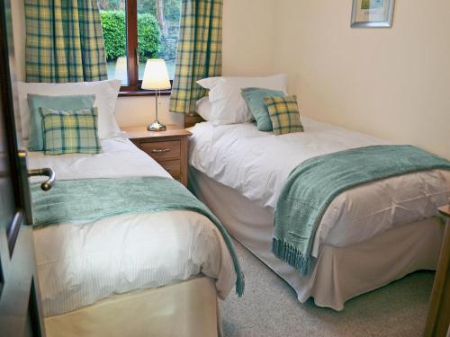 Duas camas sentadas uma ao lado da outra num quarto em Kims Retreat em Windermere