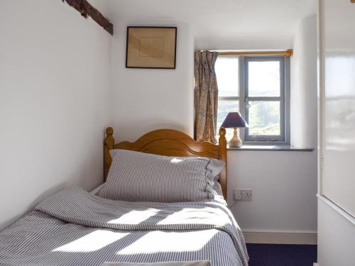 ボウネス・オン・ウィンダミアにあるThe Cottageのベッドルーム(ベッド1台、窓付)