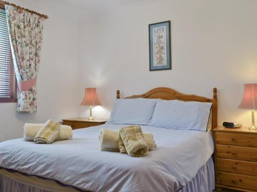 a bedroom with a bed with two pillows on it at Kingfisher Cottage in Pitlochry