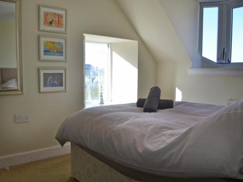 a bedroom with a large bed with a window at Dolphin Cottage in Nairn