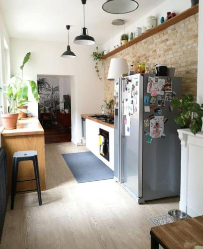 a kitchen with a stainless steel refrigerator with magnets at Chez Samuel à Dieppe in Dieppe