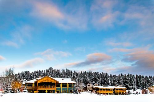 a group of school buses parked in the snow at Rainbow Ranch Lodge in Big Sky Canyon Village