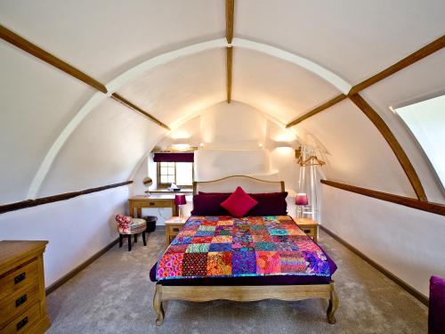 una camera con un letto con una trapunta colorata di The Chapel - Chard a Wambrook