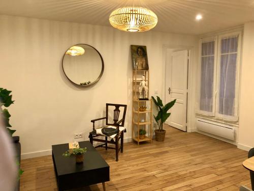een woonkamer met een spiegel en een stoel bij Rare appartement d'architecte en haut de Montmartre in Parijs