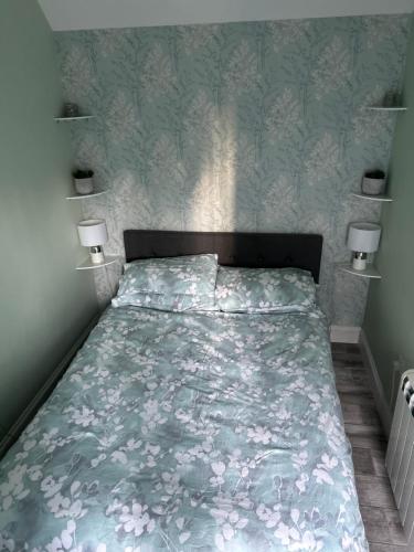 a bedroom with a bed with a floral bedspread at 44 Inaclete Road in Stornoway