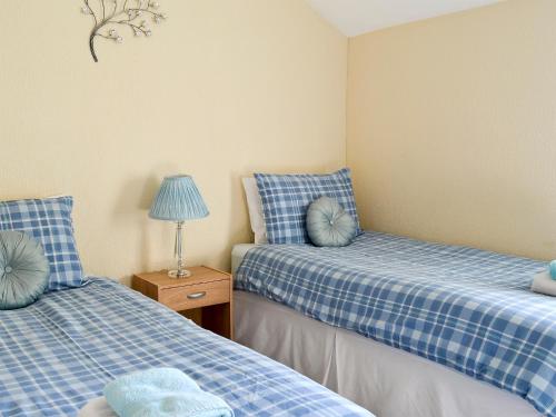 Pokój z dwoma łóżkami i lampką na stole w obiekcie Mill View House w Scarborough