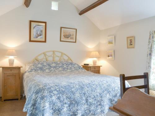 um quarto com uma cama com um edredão azul em Bryn Tirion em Llantrisant