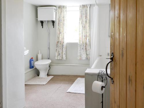 a bathroom with a toilet and a tub and a window at Bryn Tirion in Llantrisant