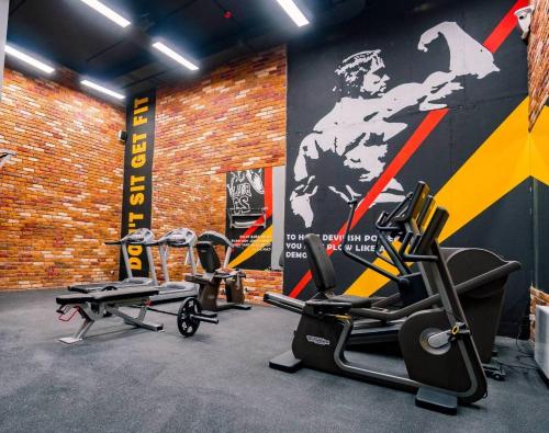 a gym with cardio equipment and a brick wall at Rechnaya in Astana