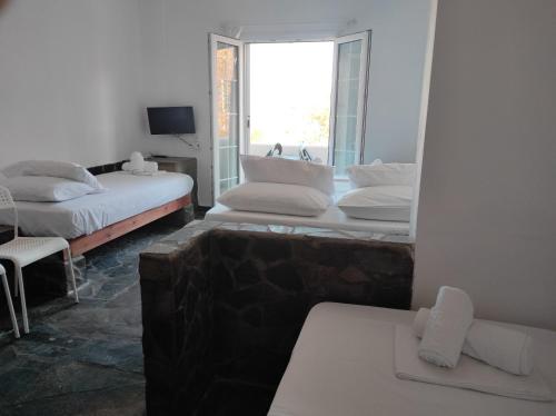 KorissiaにあるKea Island IIのベッド3台と窓が備わる客室です。