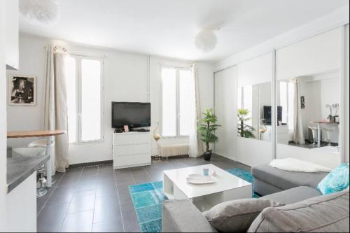 a white living room with a couch and a tv at Beau studio près de la TOUR EIFFEL / ROLAND GARROS in Boulogne-Billancourt