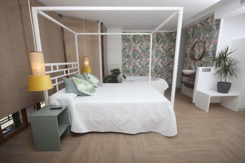 ein Schlafzimmer mit einem weißen Bett mit Baldachin in der Unterkunft APARTAMENTOS GORI SUITES HIDROMASAJE accesibles minusválidos in Villafranca del Cid