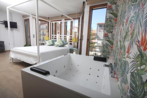 ein Bad mit Badewanne und ein Bett in einem Zimmer in der Unterkunft APARTAMENTOS GORI SUITES HIDROMASAJE accesibles minusválidos in Villafranca del Cid