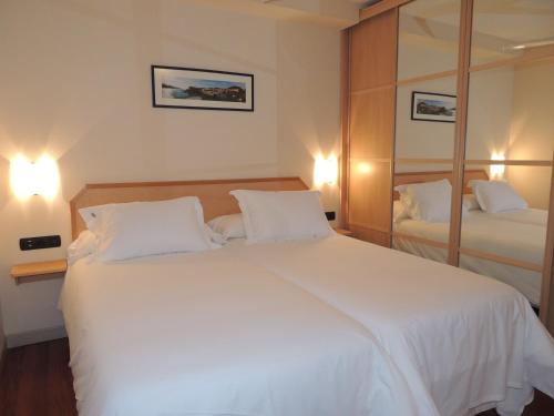 
a hotel room with a bed and two lamps at Apartamentos Mundaka in Mundaka
