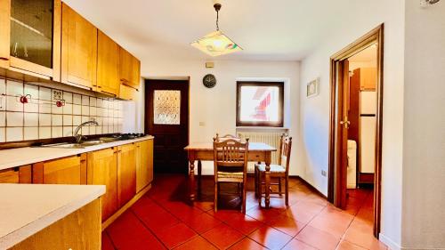uma cozinha com uma mesa e cadeiras em PredazzoHouse em Predazzo