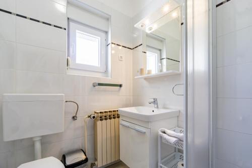 a bathroom with a toilet and a sink and a mirror at Erica perfect central location near beach in Novalja