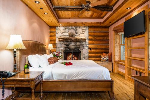 1 dormitorio con 1 cama y chimenea en Rainbow Ranch Lodge, en Big Sky Canyon Village