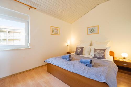 a bedroom with a bed with blue pillows on it at Erica perfect central location near beach in Novalja