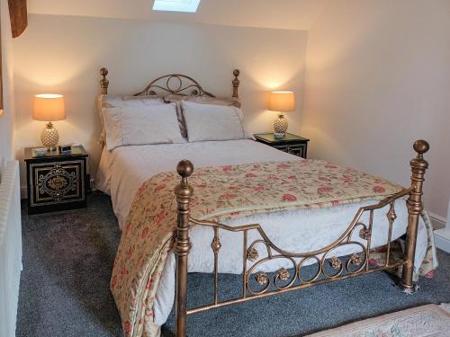 a bedroom with a bed with two end tables at Honeymead Cottage in Wick