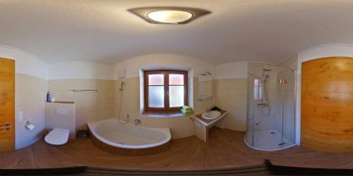 a bathroom with a tub and a shower and a sink at Ferienhof Turmkeller in Grieskirchen