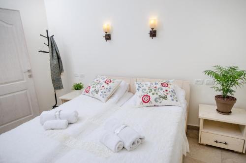 a bedroom with a white bed with towels on it at The Spirit Of Tzfat Villa in Safed