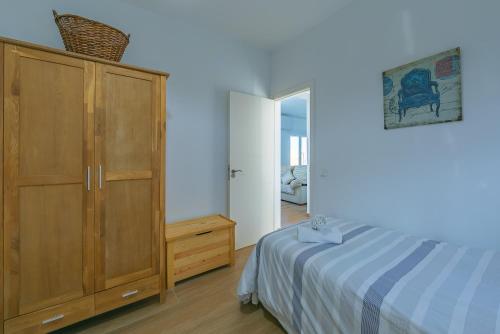 タリファにあるApto tranquilo en casco antiguoのベッドルーム1室(ベッド1台付)、木製キャビネットが備わります。