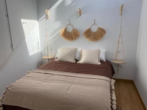 a bedroom with a bed with two baskets on the wall at Apartamento en primera línea de playa in El Rompido