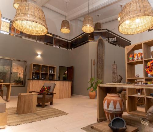 a room with tables and chairs and pendant lights at Nomads in Lomé
