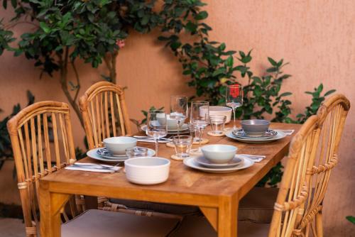 a wooden table with glasses and plates on it at Nomads in Lomé