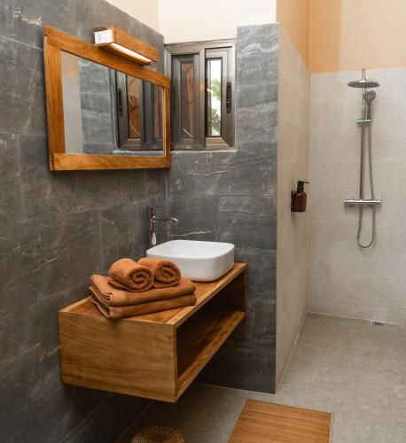 a bathroom with a sink and a mirror and towels at Nomads in Lomé