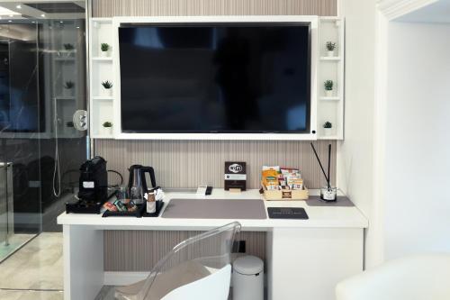 a white desk with a large television on a wall at Domus De Cinti in Tivoli