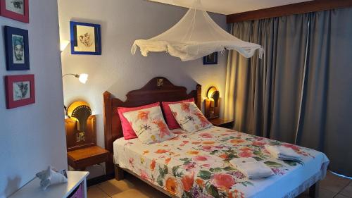 a bedroom with a bed with a canopy at Ti Studio Creole Mahogany in Sainte-Anne