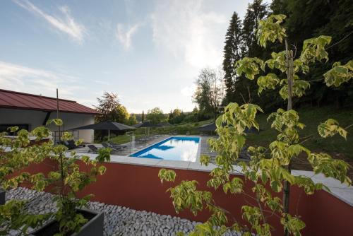 a swimming pool in a yard with trees at Hotel Bavaria in Zwiesel