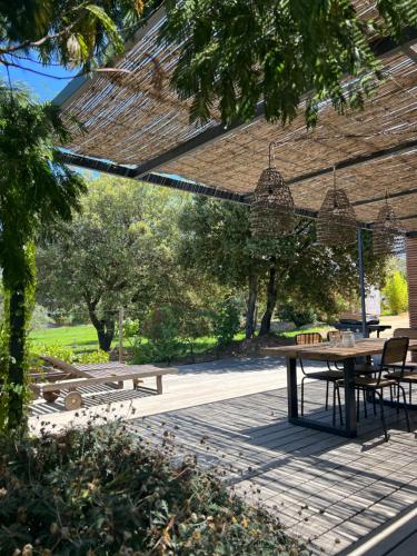 un patio con mesa, sillas y árboles en Casa Legna en Pigna