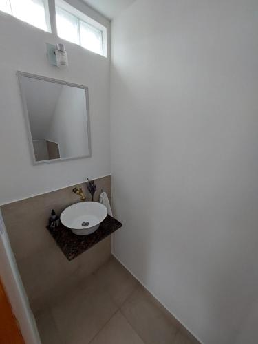 a white bathroom with a sink and a mirror at departamento temporario in Esquel