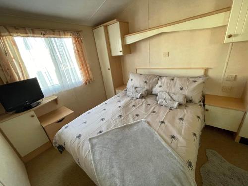 a bedroom with a bed and a television in it at Mawson Retreat Dog Friendly Static Caravan in Millom