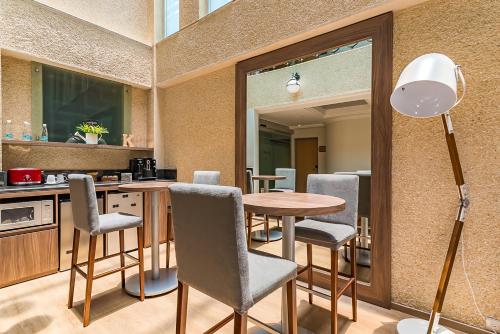 a kitchen with a table and chairs and a lamp at KALI Escandón Mexico City in Mexico City