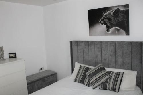 a bedroom with a bed with a wolf picture on the wall at Lovely Modern Apartment Close to Town Centre in Lexden