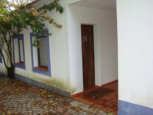 un edificio blanco con puerta y ventana en Quarto pequeno 515 do Monte dos Arneiros, en Lavre