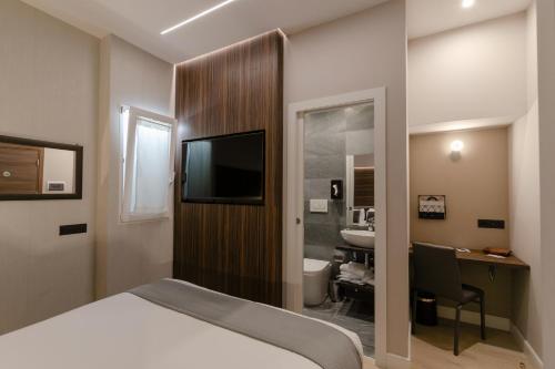 ein Hotelzimmer mit einem Bett, einem Schreibtisch und einem TV in der Unterkunft Aiello Hotels - Duomo in Mailand