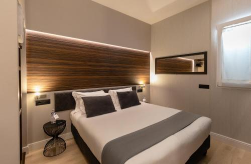 a bedroom with a large bed with a wooden headboard at AH - Duomo Essence in Milan