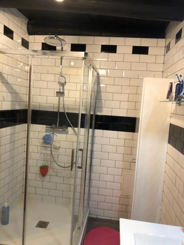 un bagno con doccia e piastrelle bianche di AUVERGNE Aux 3 boussets 