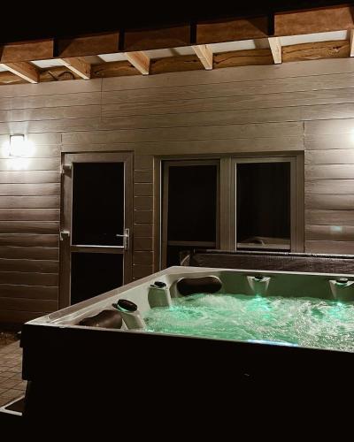 a large bath tub with green water in a room at Apartamenty Wilga spokojne miejsce z całorocznym jacuzzi i letnim basenem in Wilga