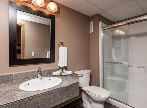 a bathroom with a toilet and a sink and a shower at Prime Hotel in Fort McMurray