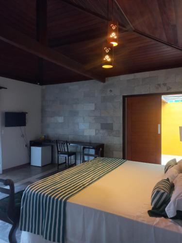 a bedroom with a large bed and a table at Pousada Spa dos Amores in São Miguel do Gostoso