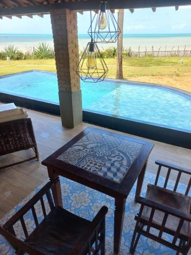 a table and chairs in front of a swimming pool at Pousada Spa dos Amores in São Miguel do Gostoso