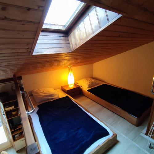 sypialnia na poddaszu z 2 łóżkami i oknem w obiekcie Appartement cosy à quelques pas de la plage de la Rémigeasse w mieście Dolus d'Oléron