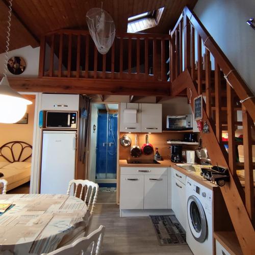 une cuisine avec un escalier menant à un loft dans l'établissement Appartement cosy à quelques pas de la plage de la Rémigeasse, à Dolus-d'Oléron